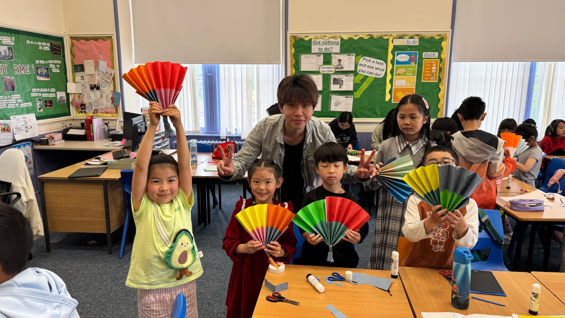 Vince with pupils holding completed colourful paper fans