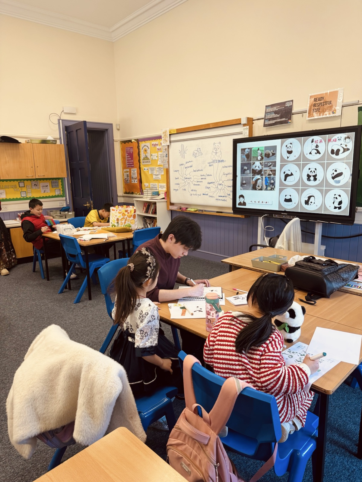 Vince drawing alongside pupils in a panda lesson