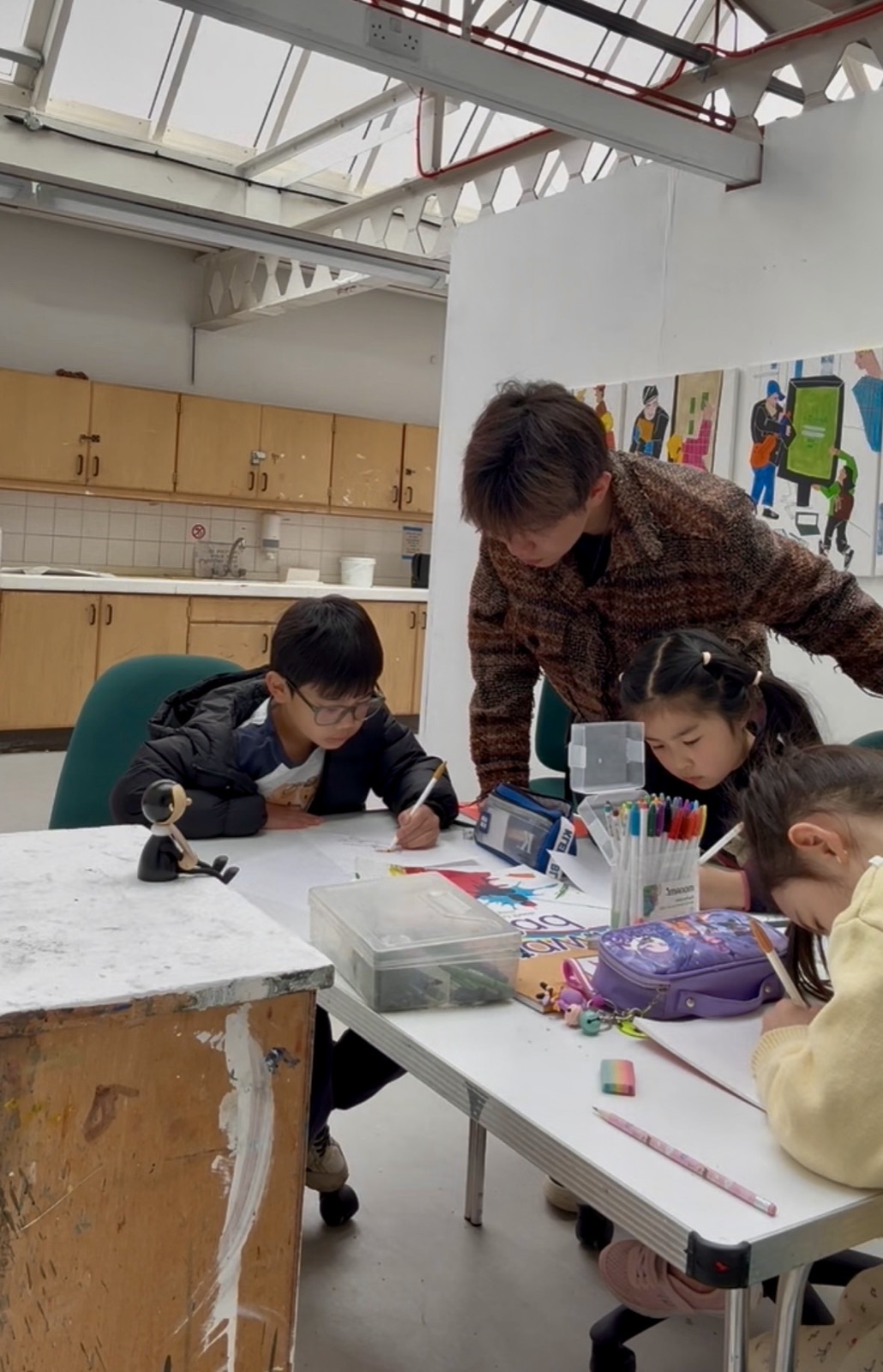 Vince supporting children at a drawing table