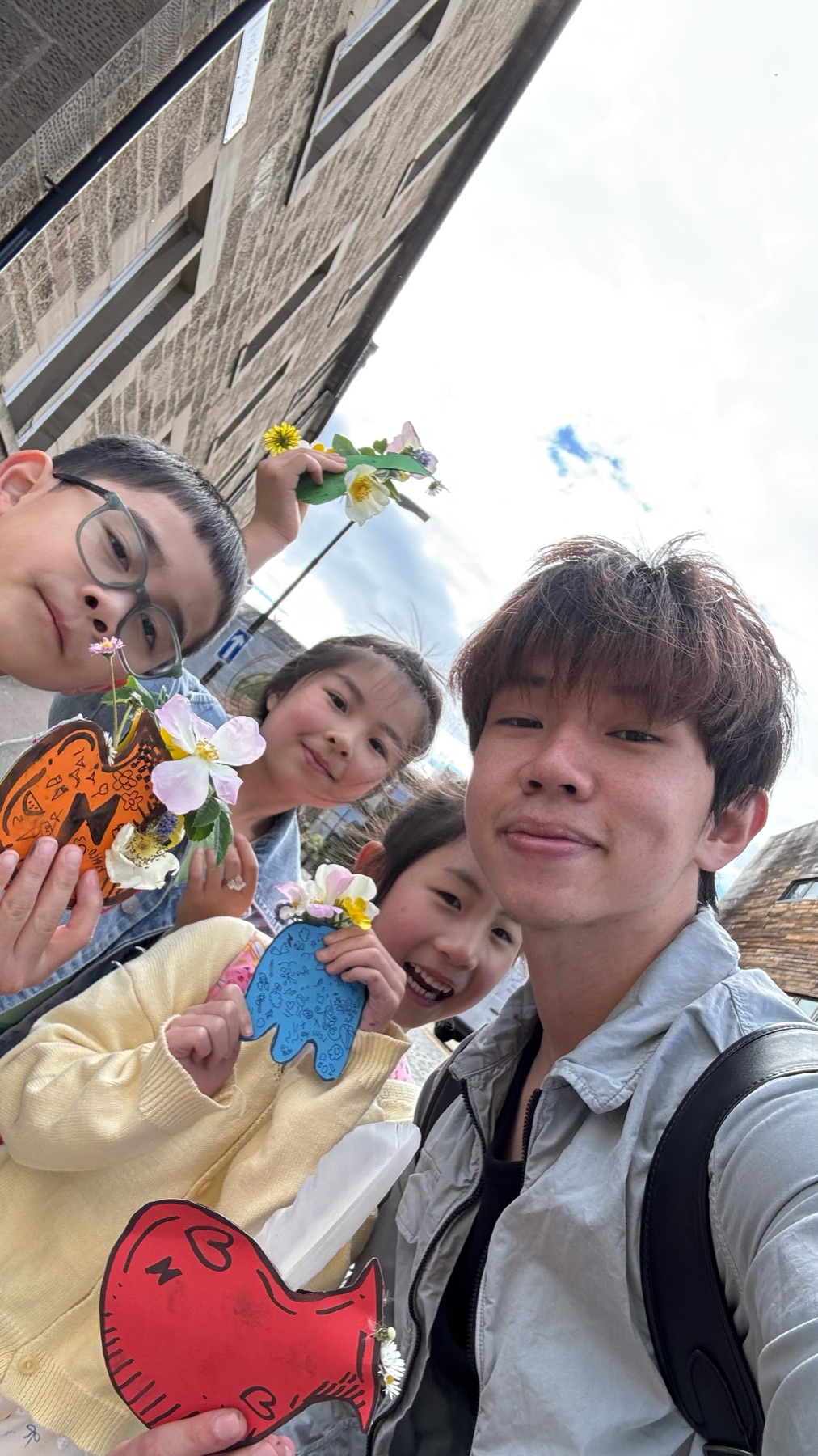 Vince and pupils exploring art outdoors with flowers and handmade drawings